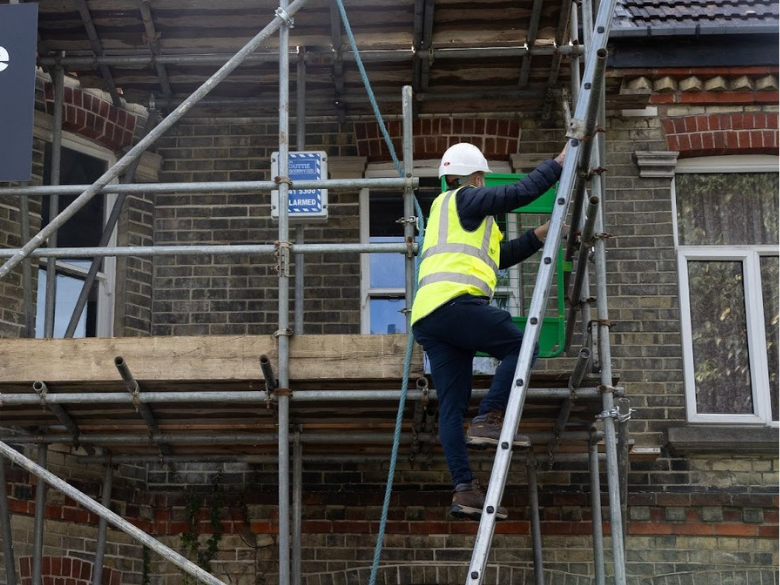 construction worker on a ladder working at height